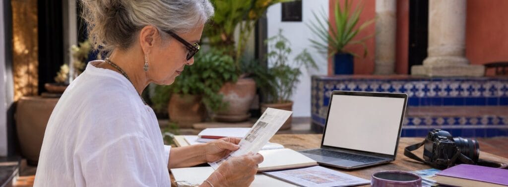 MexPat Guide editor reviewing Mexico relocation notes in a warm courtyard workspace