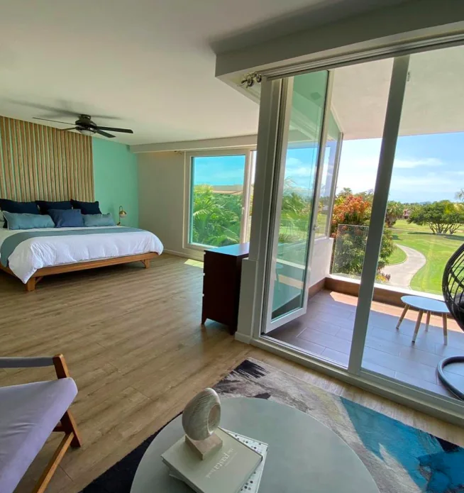 Wooden bed, ceiling fan and sliding garden doors in a Casa Palmar bedroom in Nuevo Nayarit.