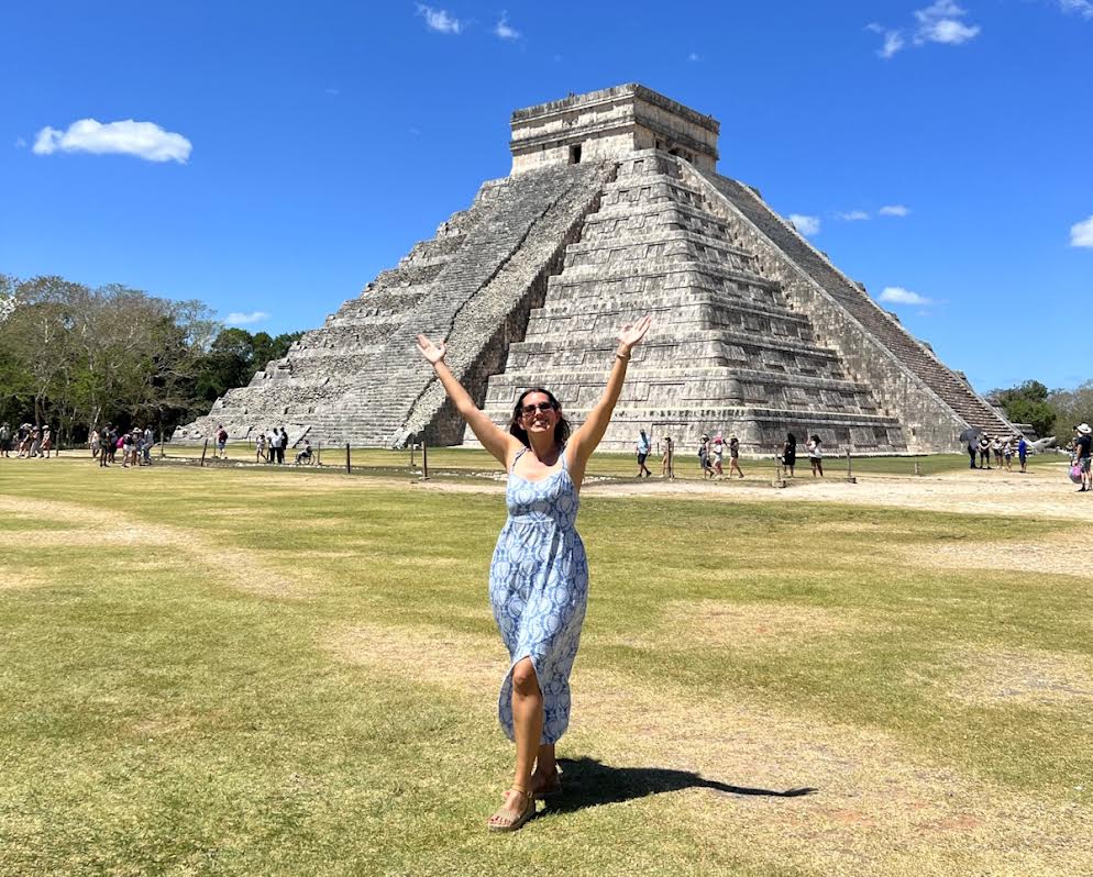 Estela Gómez standing in front of the pyramid at Chichén Itzá